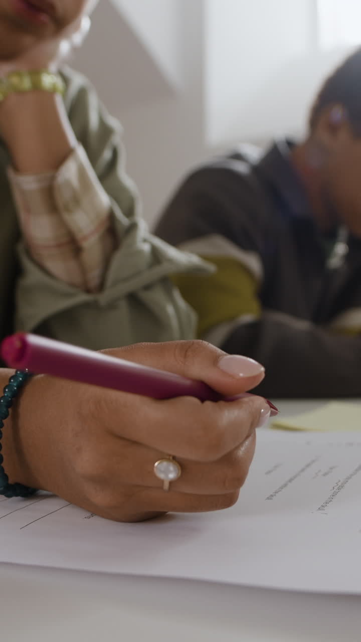 Close-up of person writing on paper with a pen