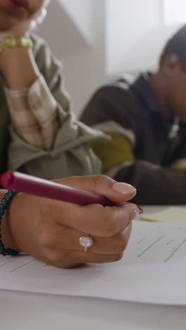 close-up of person writing on paper with a pen