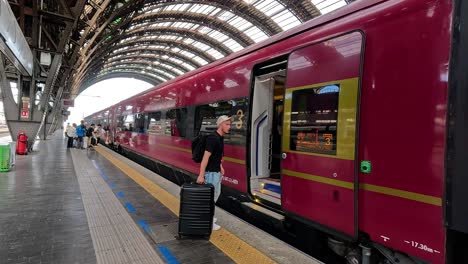 a person boards a train at milan station