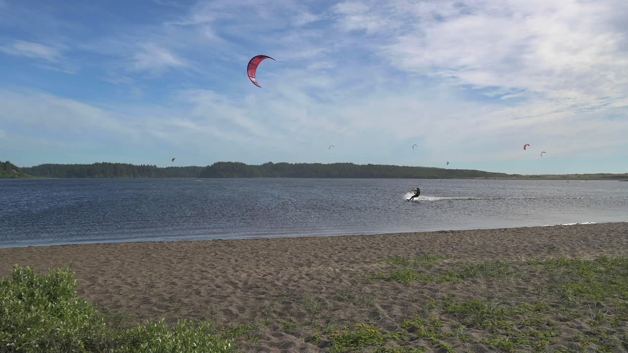 paisaje de kitesurfer solitario en agua ondulante bajo un cielo azul en el lago floras, oregon