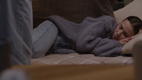 une femme qui dort confortablement sur un canapé.