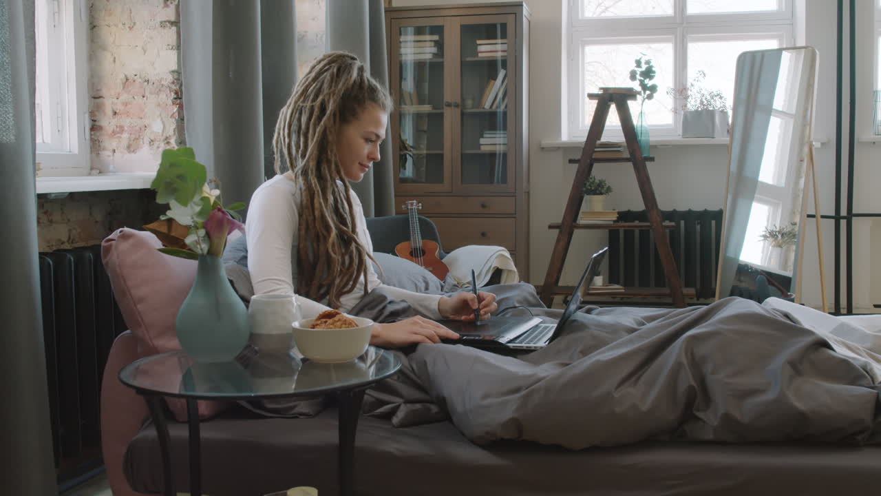 Digital Designer Working In Bed While Having Breakfast