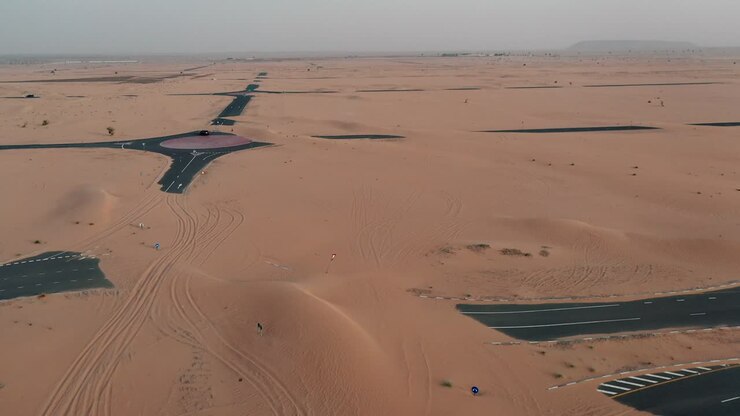 Filmato drone 4K, una strada nel deserto, la Half Desert Road di Dubai, paesaggio geologico di deserto con alte dune negli Emirati Arabi Uniti, video di droni.