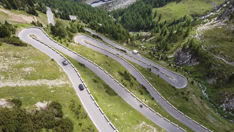 aerial top down drone view of the stelvio mountain pass road in italy - cars and motor driving the hairpins curves