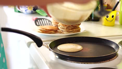 woman chef pouring pancake batter on a frying pan