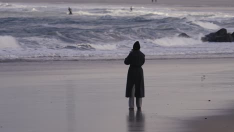 Chica-En-La-Playa-Viendo-Kitesurf-En-Las-Olas-Del-Océano,-Vista-Estática,-Espacio-De-Copia