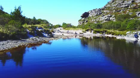 Vista-Aérea-Sobre-El-Lago-En-Las-Montañas-Durante-El-Verano