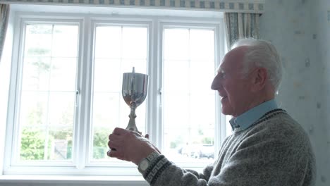 senior caucasian man holding his trophy