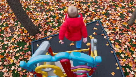 child playing on a colorful playground in autumn