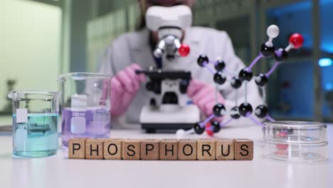 a scientist working in a laboratory with a microscope, beakers, and a phosphorus molecular model