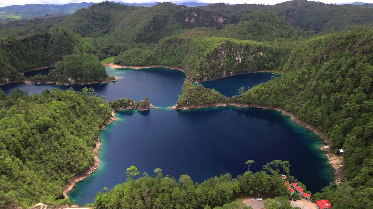 Langsomt luftbårent dronepanorama, der afslører forbundne dybblå søer omgivet af skovklædte bakker i Montebello Lakes Nationalpark i Chiapas, Mexico