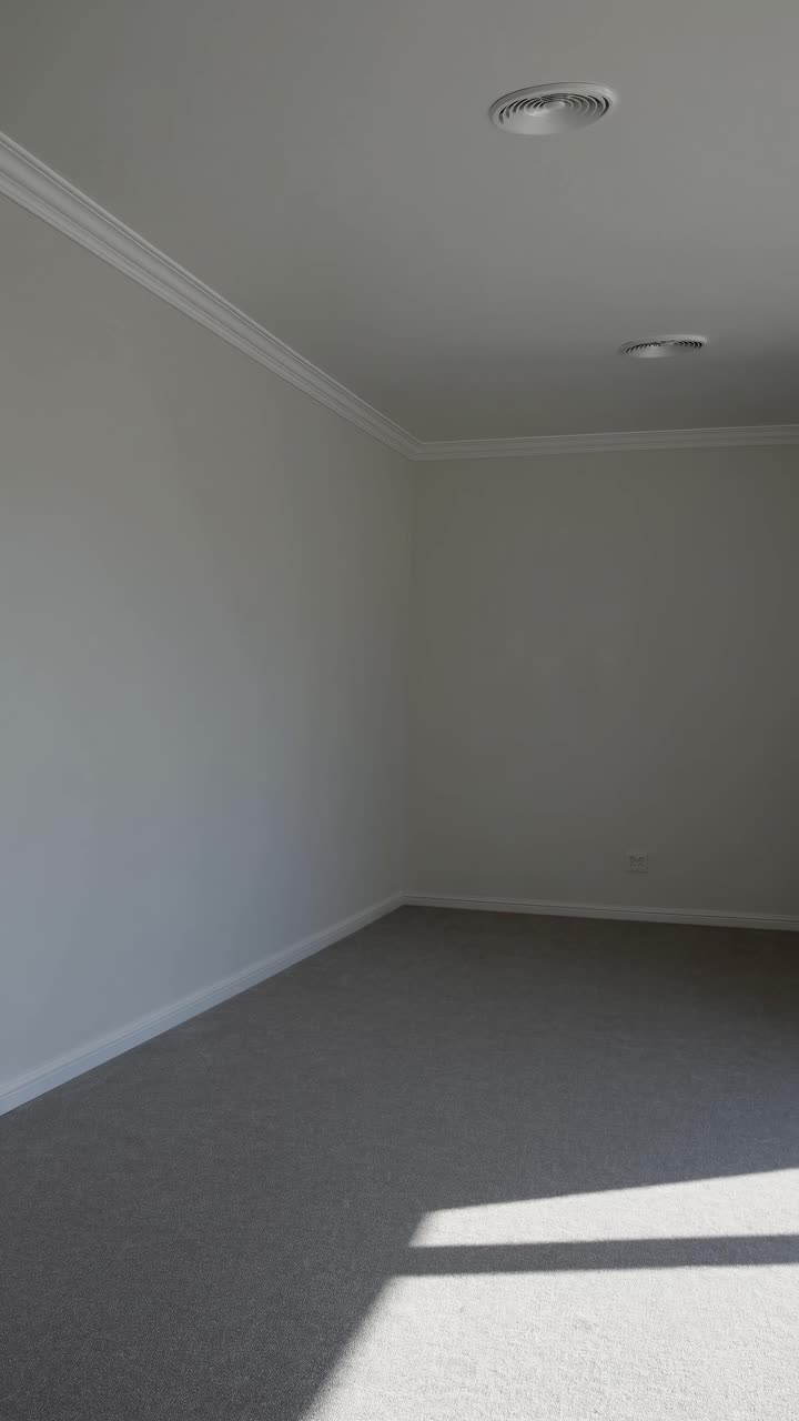 Stanza vuota minimalista con illuminazione soffusa, ripresa da un'angolazione bassa.