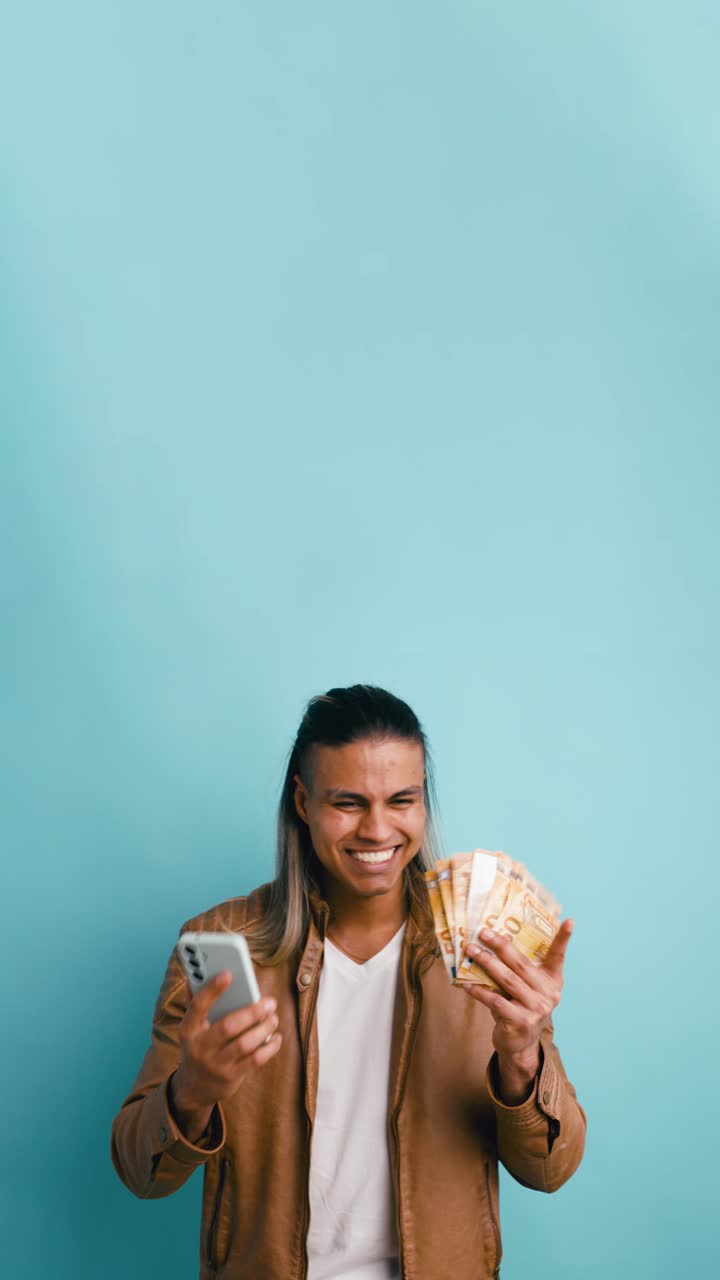 Joven feliz sosteniendo un smartphone y contando billetes de euro