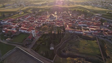 tilt up shot of touristic town almeida portugal with sun in lens at sunrise, aerial