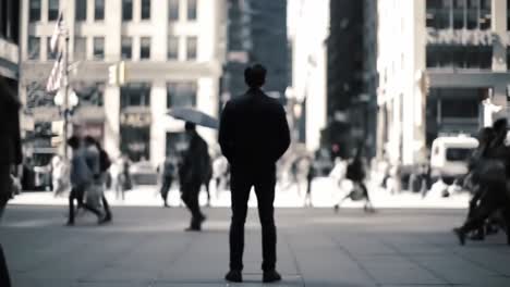 a solitary figure stands amidst the bustling city streets, observing the rapid movement of pedestrians in a vibrant urban environment, capturing the essence of daily life.