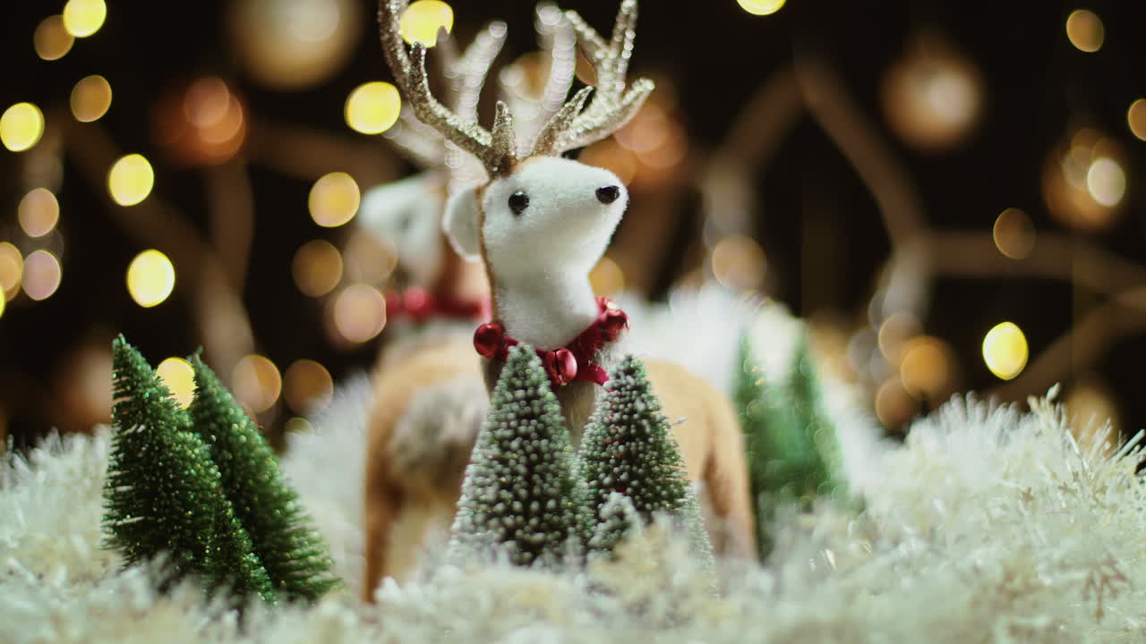 Rotating festive reindeer figures and miniature Christmas trees with warm bokeh lights