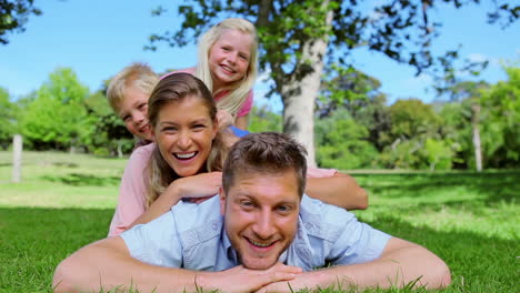 two children running towards their parents before lying on their backs