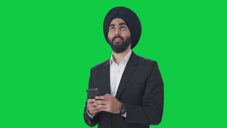 Happy-Sikh-Indian-businessman-texting-someone-Green-screen