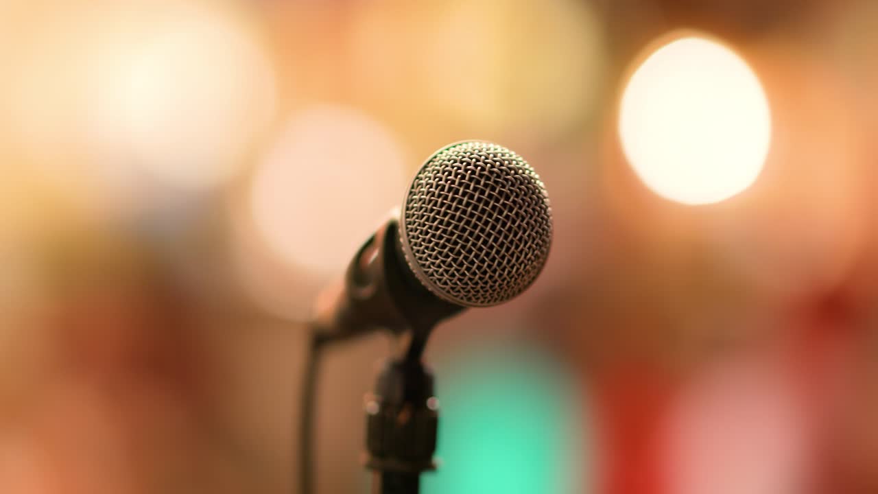 micrófono en el escenario contra un fondo de auditorio.
