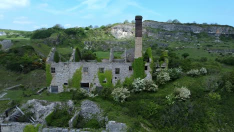 Abandoned-overgrown-ivy-covered-desolate-countryside-historical-Welsh-coastal-brick-factory-mill-aerial-view-mid-orbit-right-shot