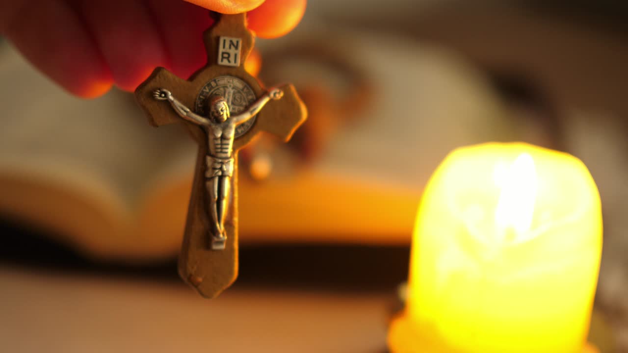 cruz con cristo jesús en el crepúsculo iluminado por la luz de la vela