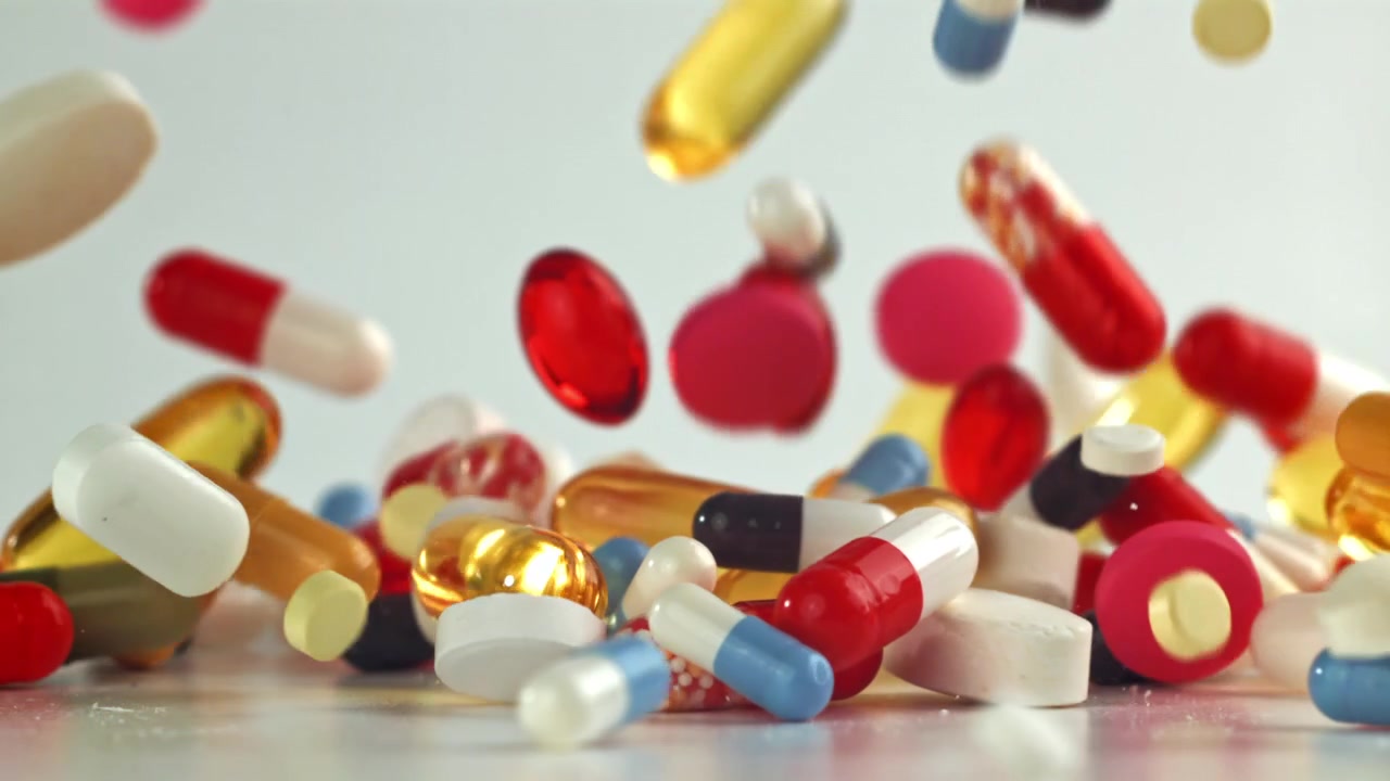 Colorful Pills and Capsules Falling in Slow Motion