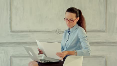 mujer de negocios atractiva leyendo estadísticas y gráficos en el papeleo