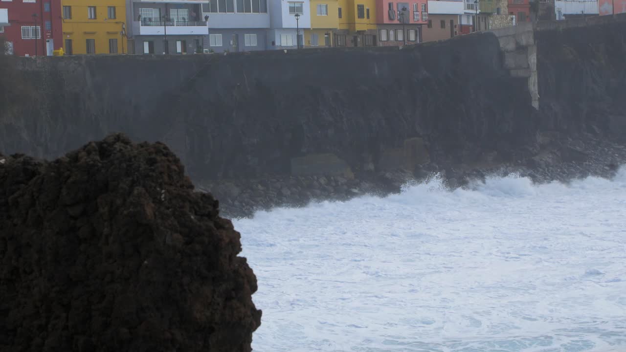 대서양의 큰 파도가 화창한 날 카나리아의 푸에르토 데 라 크루즈에서 폭풍이 몰아치는 동안 바위 해안에서 부서집니다. 중간 샷