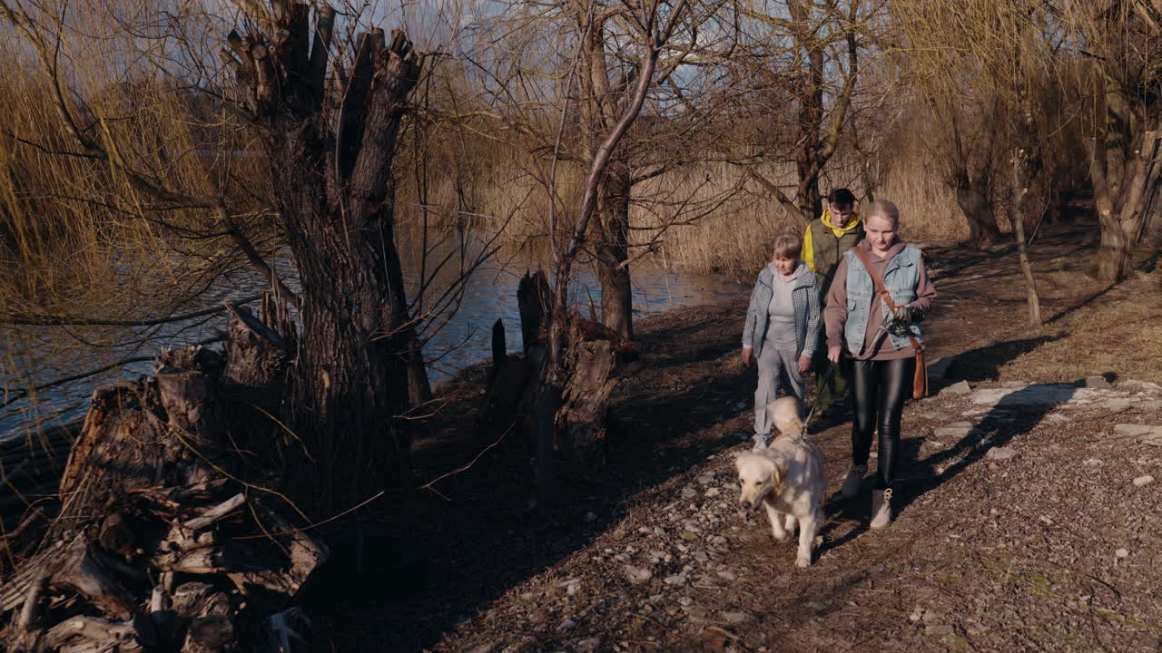 familia caminando con el perro junto al lago