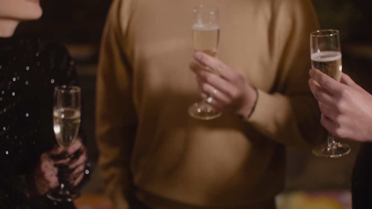 cerca de amigos irreconocibles brindando con copas de champán en la fiesta de fin de año