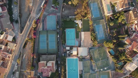 Vista-Aérea-De-Arriba-Hacia-Abajo-Durante-La-Puesta-De-Sol-De-Un-Complejo-Deportivo-En-La-Playa-De-Candado,-España-En-El-Medio-De-La-Ciudad