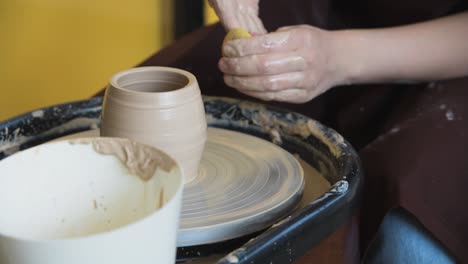 la alfarera hace una olla en la rueda de cerámica en primer plano