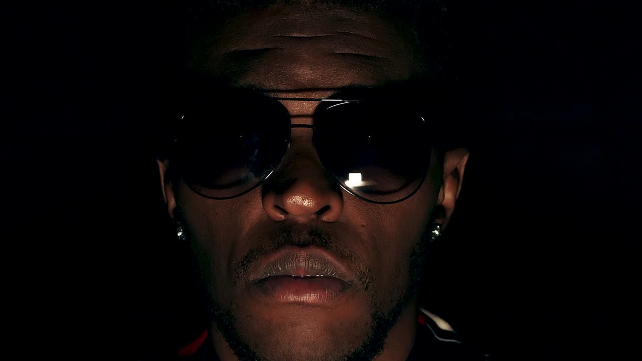 tipo elegante con cara sin emociones levantando la cabeza - comienzo, fondo negro, extremo de primer plano