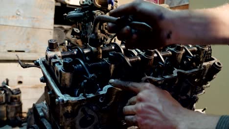 mecánico de automóviles recoge un motor de coche viejo renovado