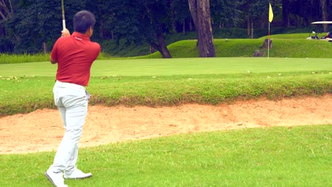 golf sport concept, golfer hitting golf ball on fairway to over bunker to green for put in golf course, beautiful fairway and layout  on nature. yellow flag on green and golf cart for transfer to hole