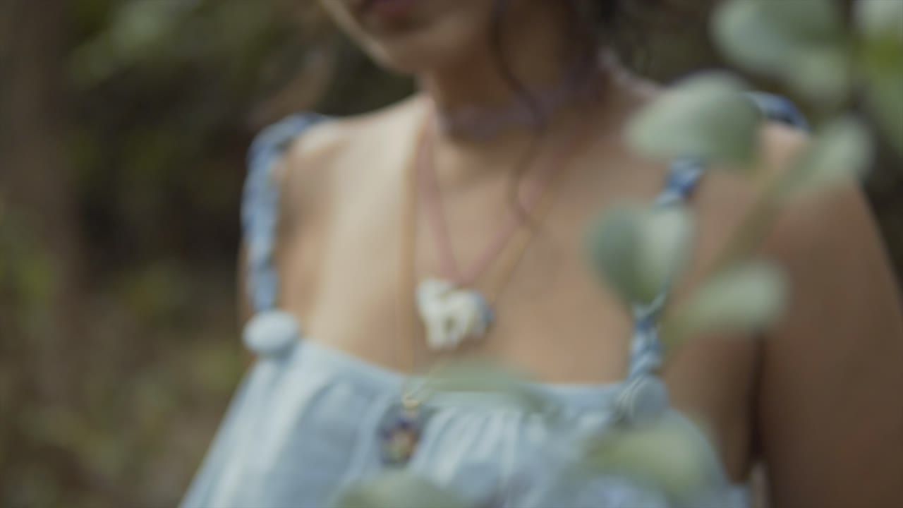 Cinematic close-up of a fashion necklase and dress of a fashion model in the tropical rainforest of Goa, India in Slow Motion, Slomo