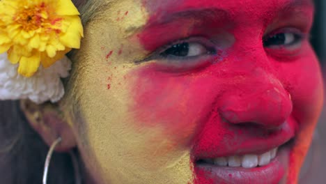 indian women close-up of face smeared with bright holi colors