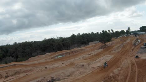 aerial pan follows slow motion motocross rider taking epic jump