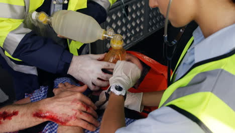 emergency medical technician taking the pulse of his wounded person