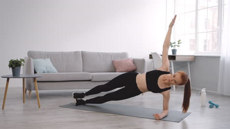mujer haciendo un ejercicio de tabla lateral en casa