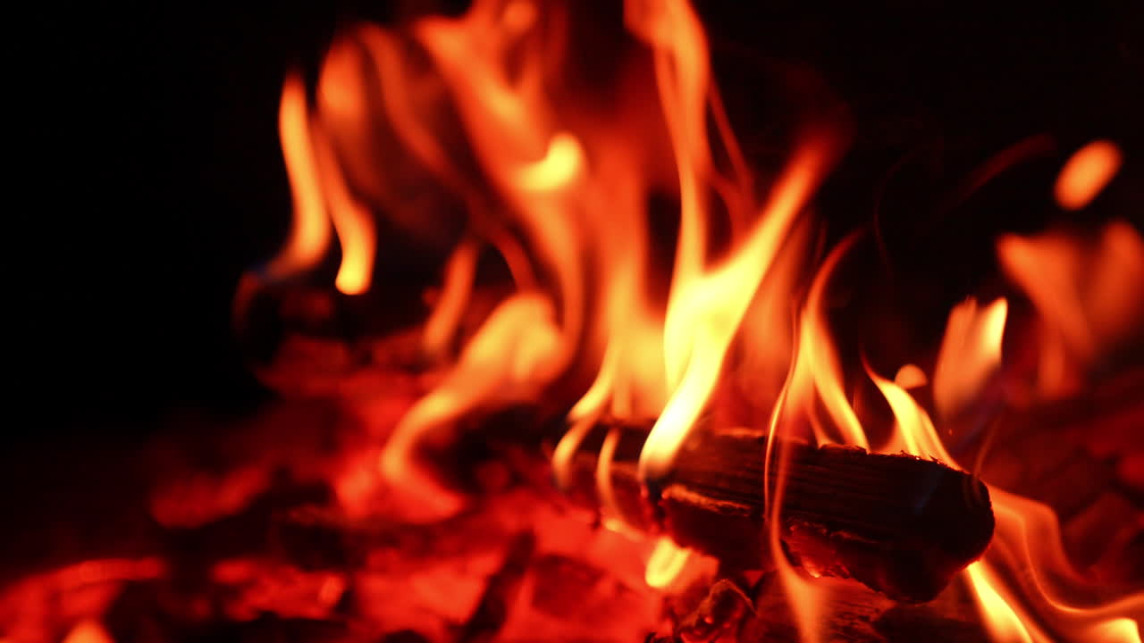 Vista sfocata del falò confortante. Tronchi di legno bruciano nel fuoco da campo. Primo piano.