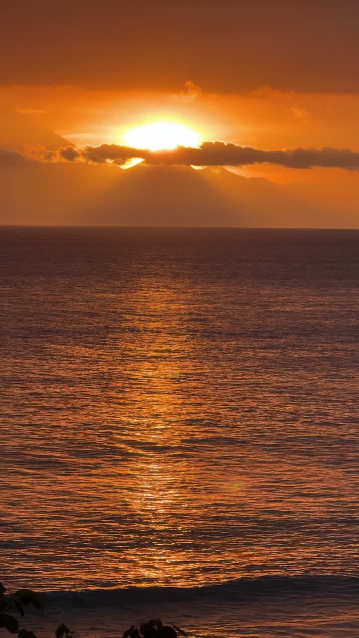 Dramatisk gylden solnedgang over havet med glitrende vand