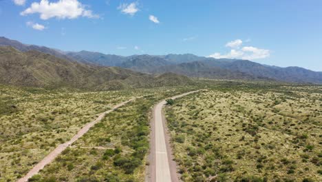 Long-lonely-road-in-the-middle-of-a-barren-landscape-on-a-sunny-day