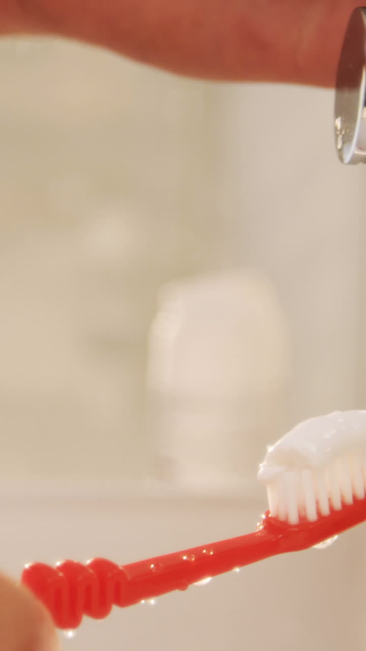 hombre poniendo pasta de dientes en el cepillo de dientes