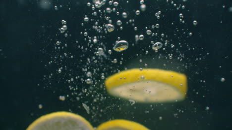 lemon splashing into water on black background closeup in super slow motion