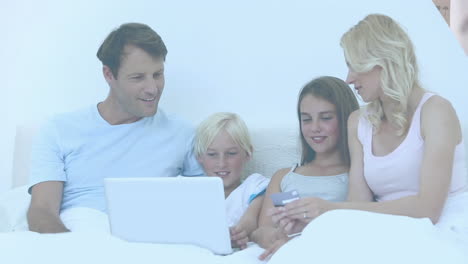 video of couple with son and daughter paying online with credit card using laptop