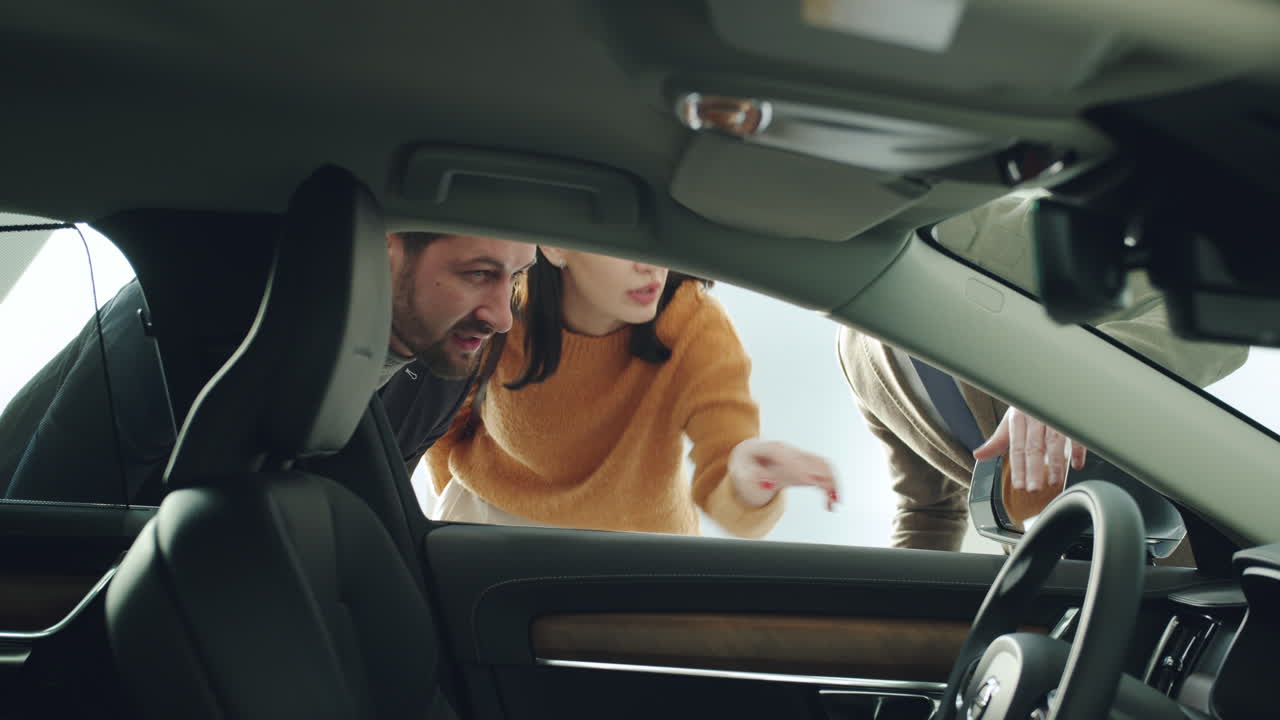 Car Salespeople & Customers Viewing the Interior of a New Volvo
