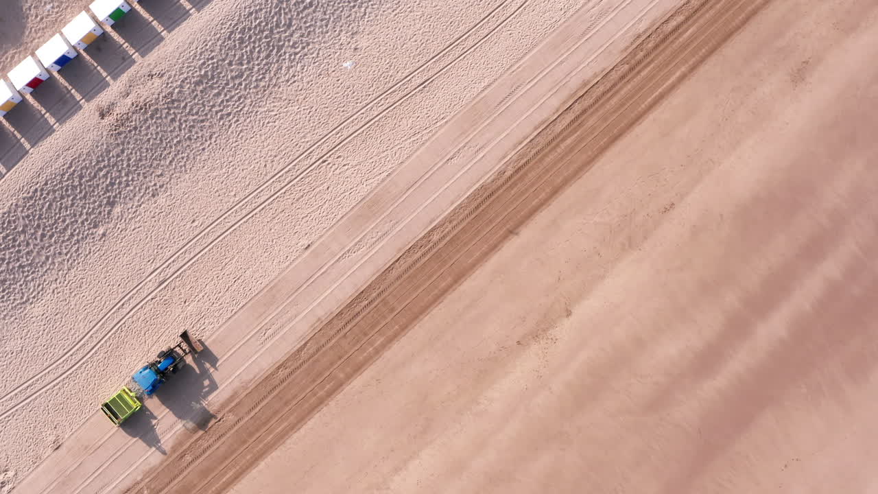 트랙터의 정적 샷 - 대각선 각도로 북쪽 데본의 모래 해변을 청소하는 트레일러