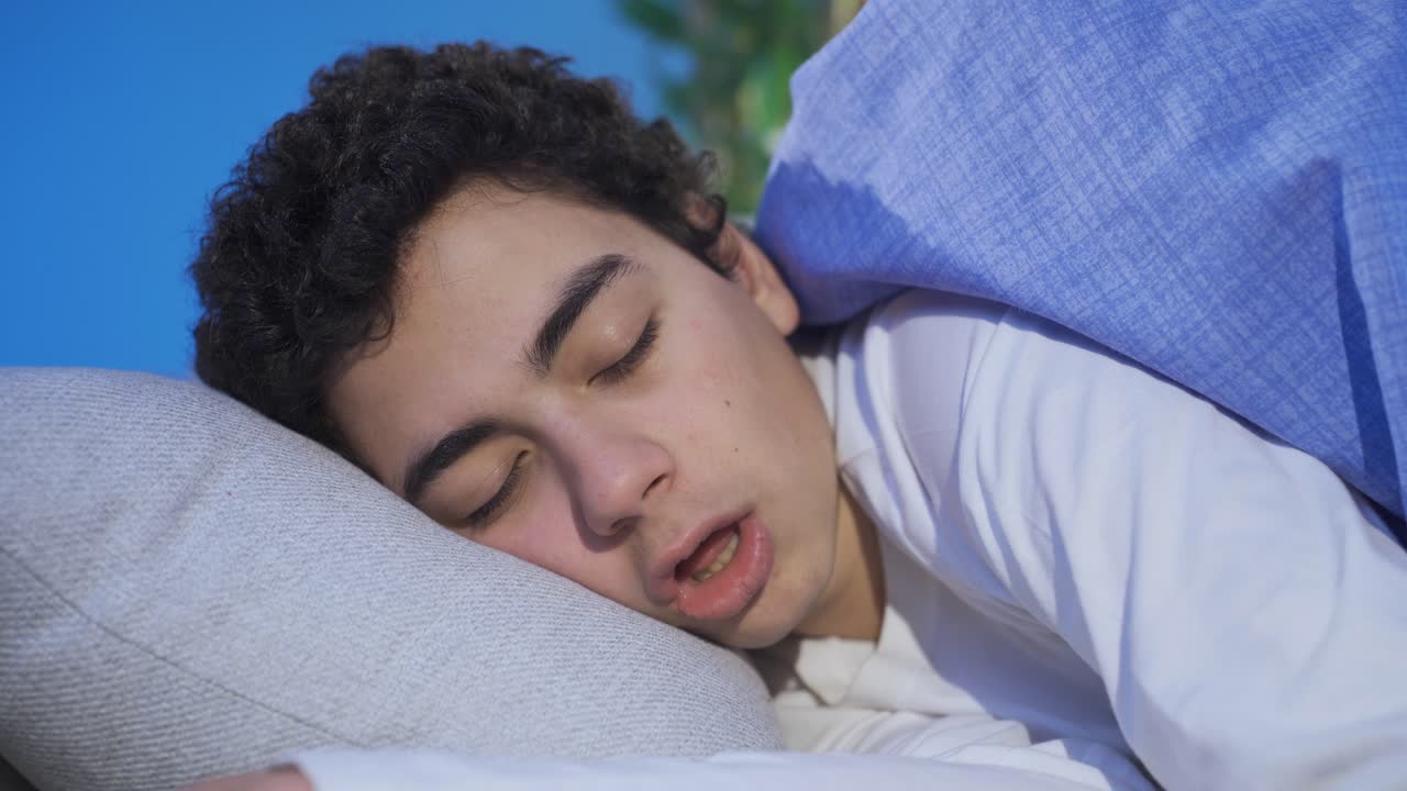 The boy sleeping at home is snoring, he can't breathe well.