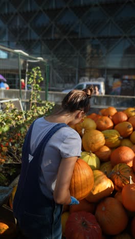 woman picking pumpkins at a market